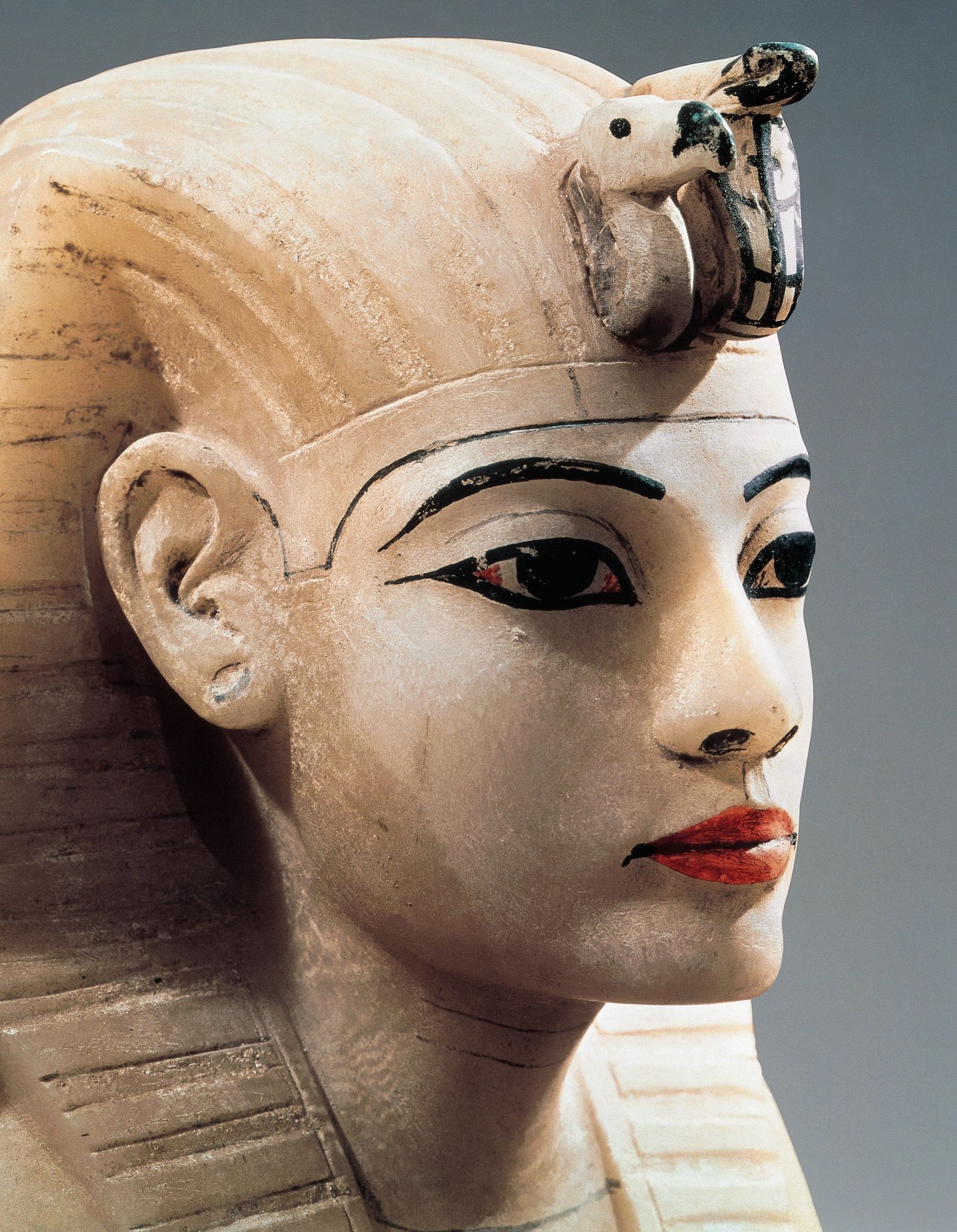 A woman with Egyptian makeup featuring a deep brown eyeliner, neutral eyeshadow and gold lip paint
